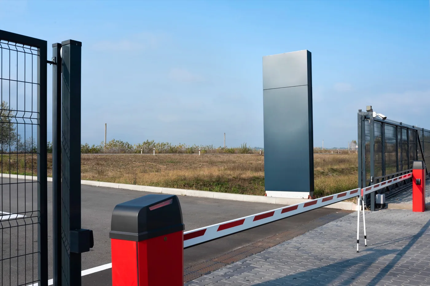 Barreras y reja de seguridad en acceso perimetral cerrado con cámara